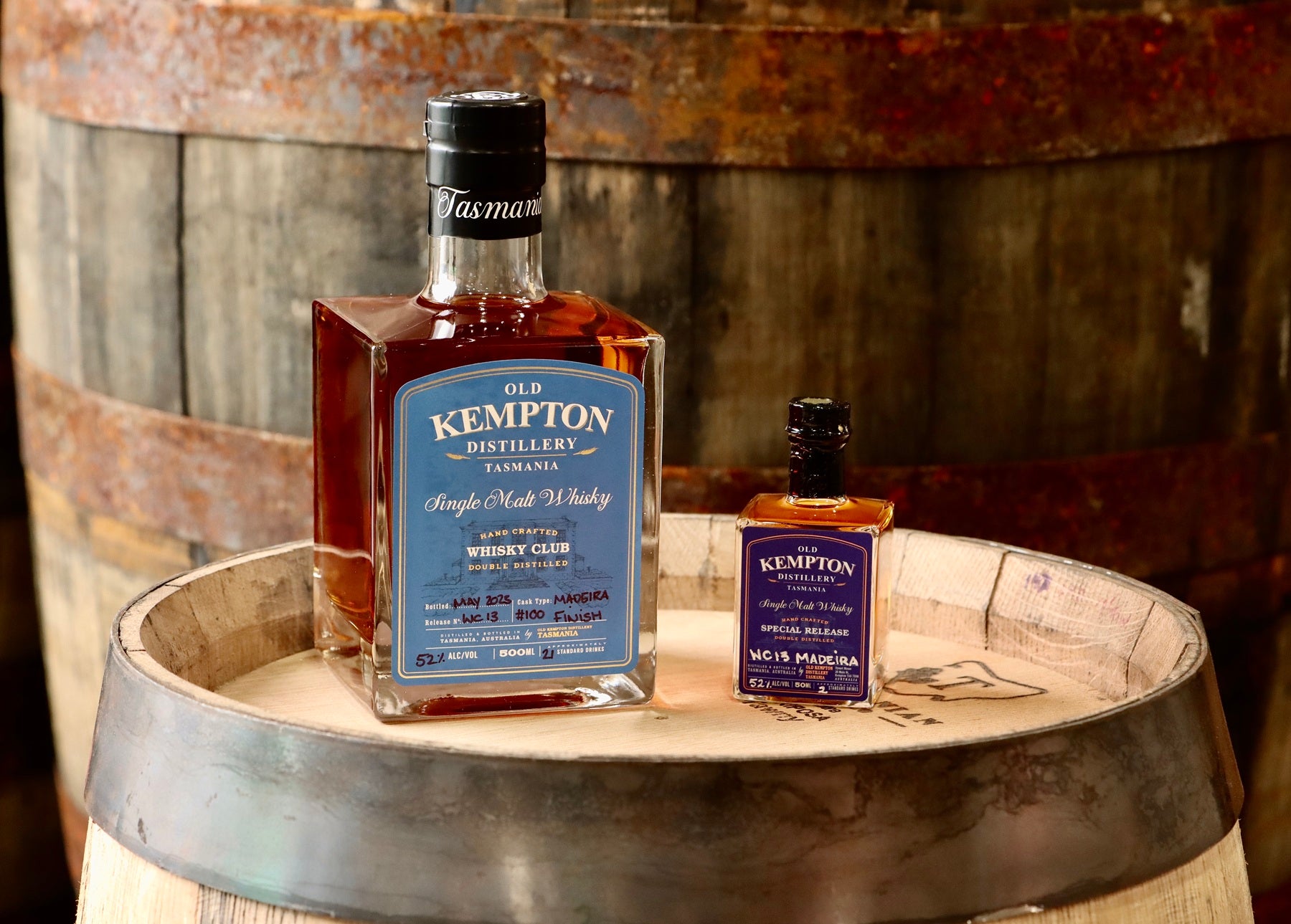Two bottles of Old Kempton whiskey on a wooden barrel
